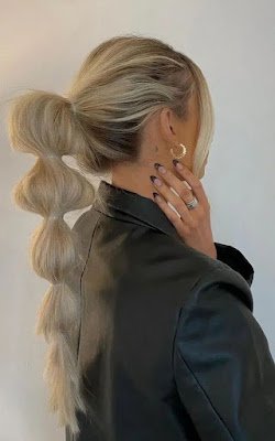 O efeito do penteado é conquistado apenas com elastiquinhos que você vai colocar pelo cabelo depois de fazer um rabo de cavalo, criando bolhas de cabelos.