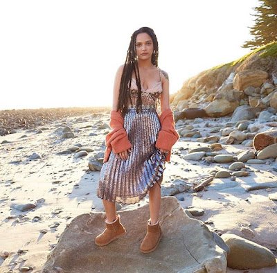 Para um visual mais boêmio, vista suas UGGs com um vestido ou saia longa fluída e acessórios rústicos, como um chapéu de feltro ou joias em tons terrosos. Este estilo é ideal para quem quer conforto sem abrir mão do charme e da feminilidade.